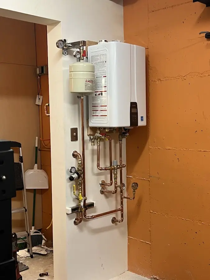 Plumbing technician inspecting water heater connections in Stratmoor